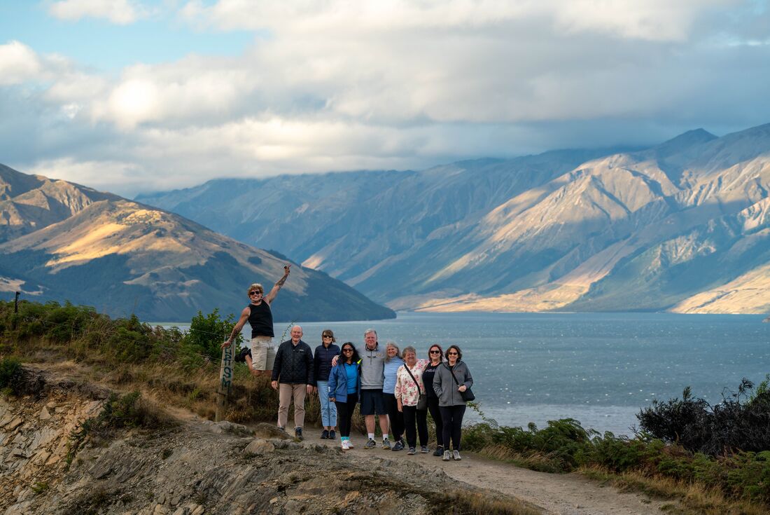 Intrepid Travellers take a photo in front of Lake Wanaka in New Zealand