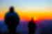 Intrepid leader Benji and traveller watch the sunset from the top of Mount Sonder