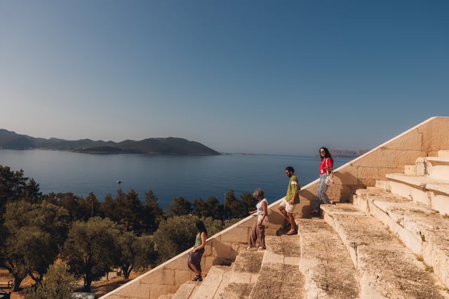 A group of four travellers walking down steps in Kas