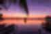 Sunset over the ocean in Caye Caulker Belize with traveller perched on the end of a dock
