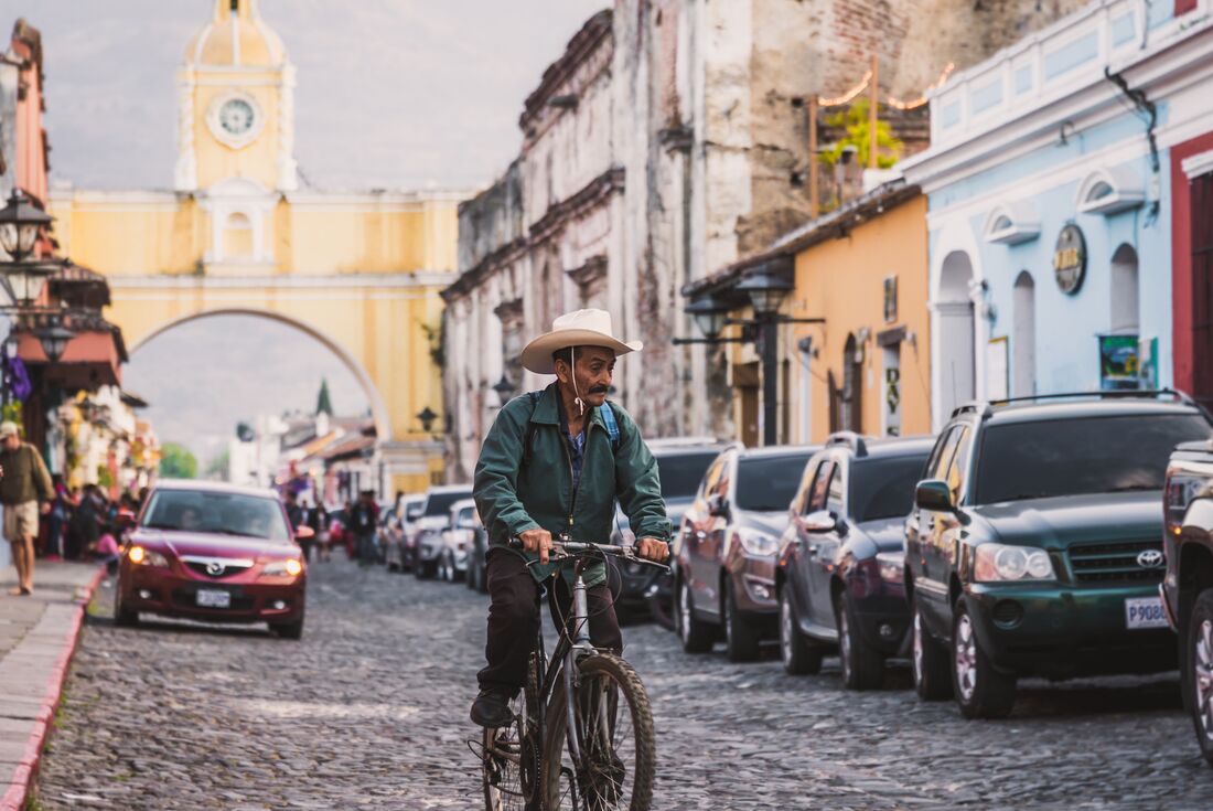 Local rides a bike down the colourful streets of Antigua, Guatemala
