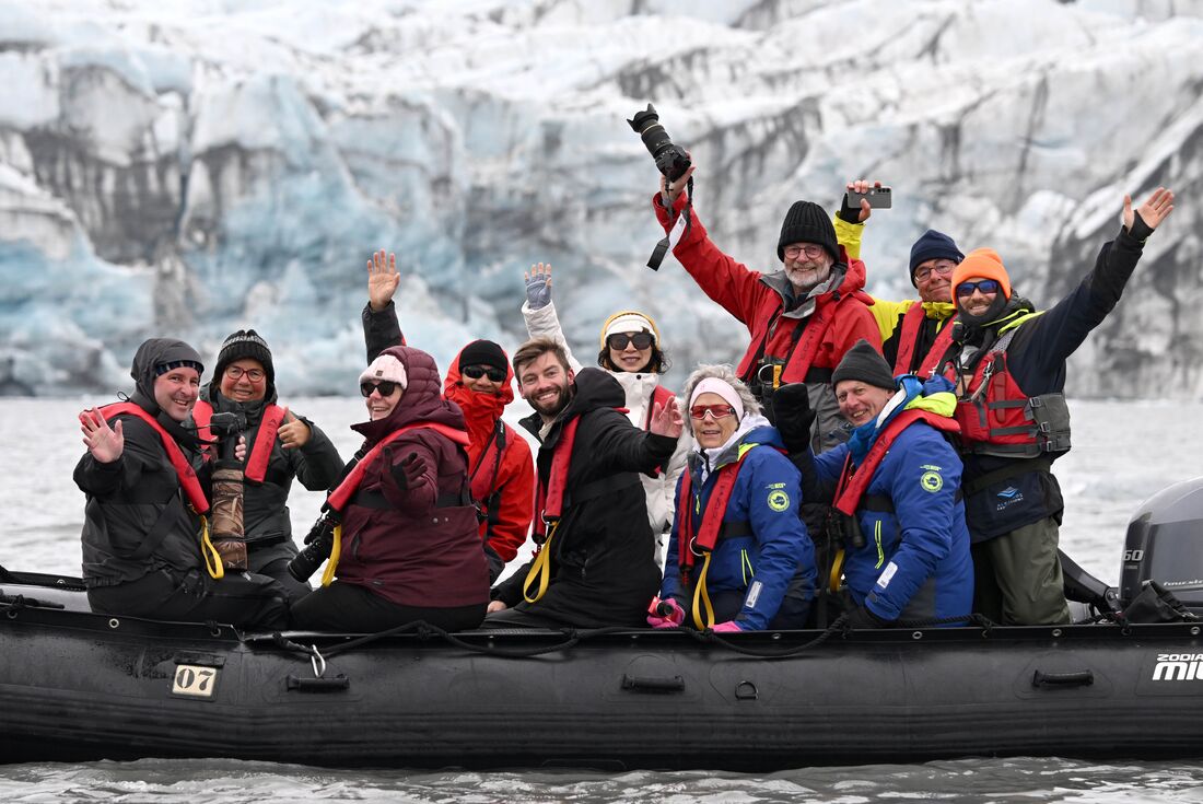 Happy travellers on a zodiac on the coast of Svalbard