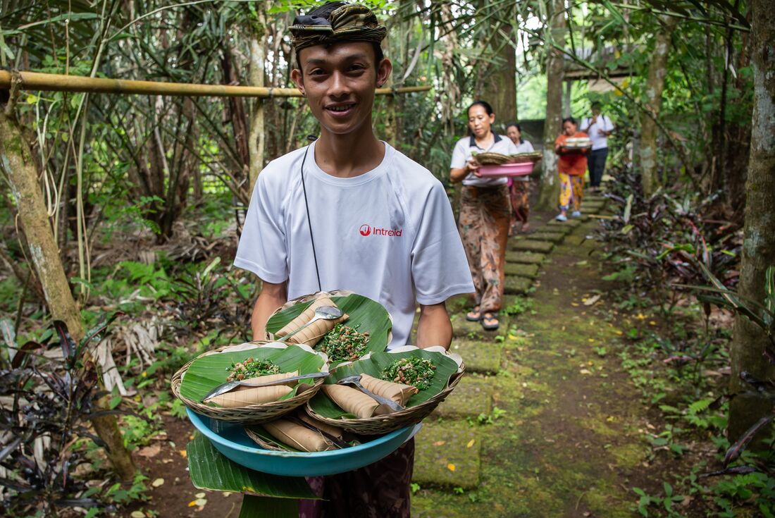 Smiling local holds up the Tipat Blayag lunch at the Salak Plantation in Sibetan village, Bali, Indonesia