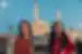 Smiling travellers with mosque behind them at dusk in Istanbul, Turkey