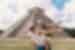 Happy mother and daughter with arms stretched out openly in front of El Castillo, Chichen Itza, Yucatán, Mexico