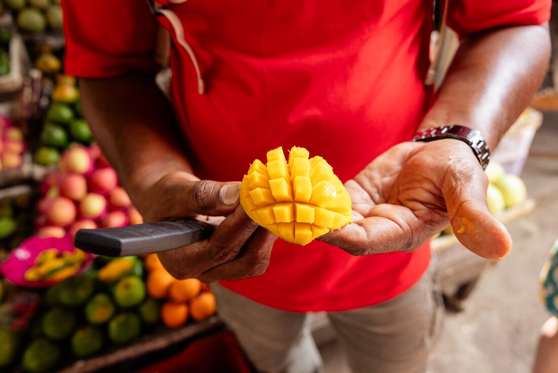 Leader shows fresh mango at market in Kandy, Sri Lanka