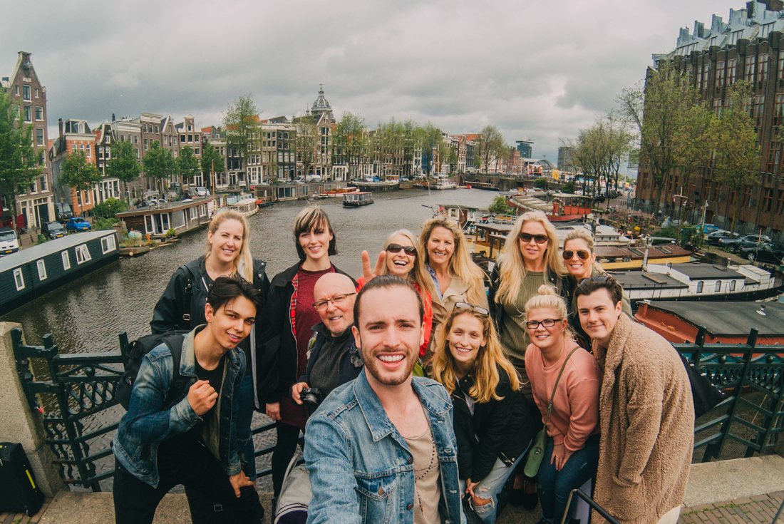 Intrepid group pose together for a photo on a high bridge in Amsterdam, Netherlands