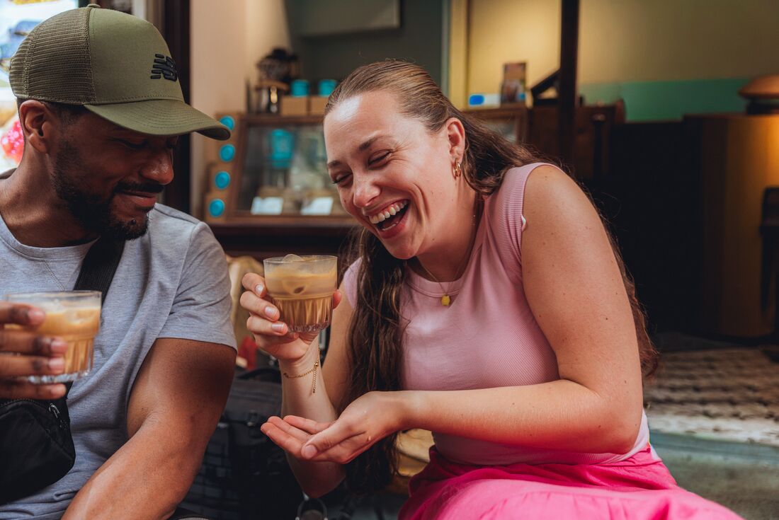 Intrepid Traveller laughing while drinking Vietnamese iced coffee