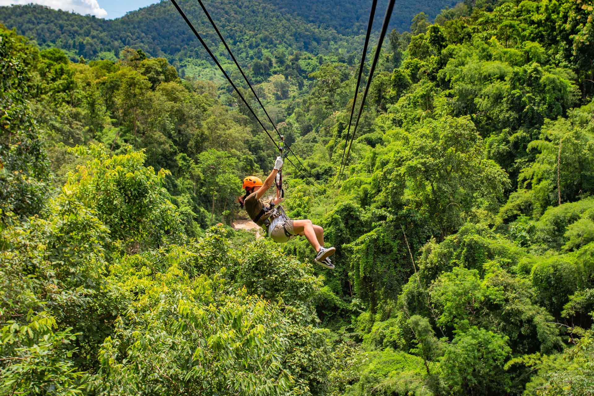 Fly over the forest canopy on a zipline through the trees in Cambodia