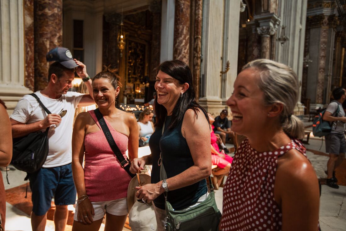 Traveller family parents laugh and smile with leader inside the Pantheon in Rome Italy