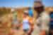 Intrepid travellers of different ages laugha and smile in the orange outback of Western Australia