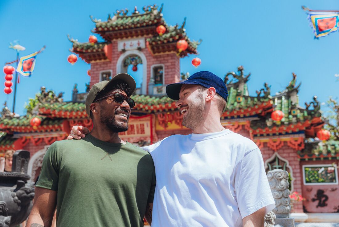 Smiling travellers in front of Fujian Assembly Hall in Hoi An, Vietnam