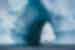 Group of travellers visible zodiac cruising through circular gap in an enormous iceberg off Antarctica Penninsula