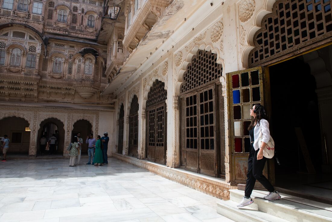 Traveller looking up at the architecture is she walks around inside Mehrangarh Fort, Jodhpur, India