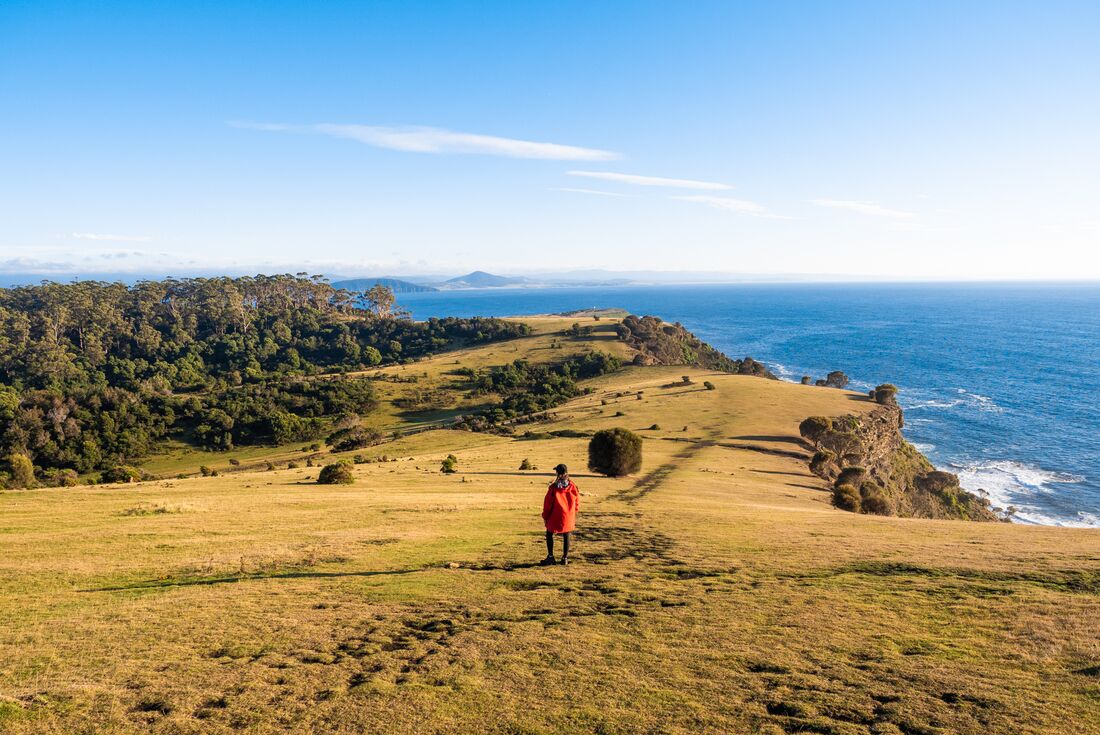 Traveller walking a path on the coastal landscape of Maria Island, Australia