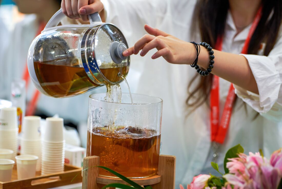 Local guide pouring fresh tea at Nannou Mountain plantation in China
