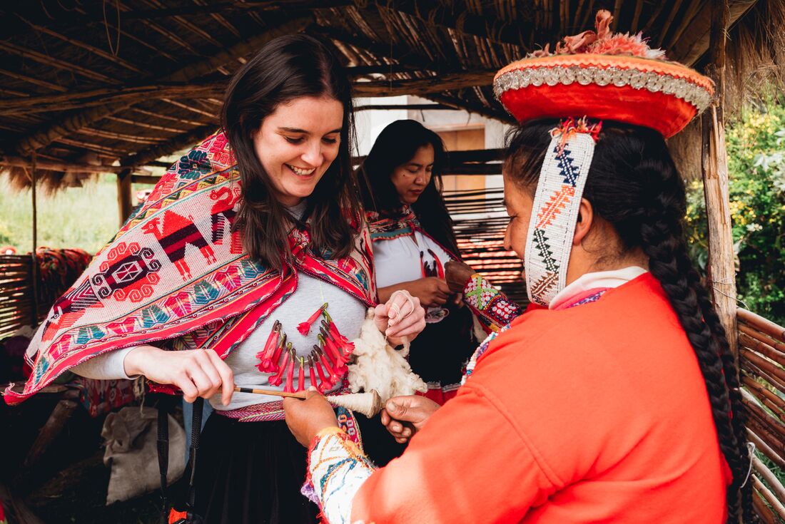 Huilloc community gifts Intrepid traveller a flower necklace in Peru