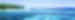 A view from a boat of a tree-lined shore and snorkellers in two-toned blue waters of the reef
