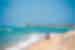 Travellers walk along the curving sandy beach of Unawatuna Sri Lanka