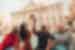 Travellers smiling as one flicks coin into the Trevi Fountain, Rome, Italy