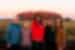 Leader and Travellers posing in front of Uluru at sunset