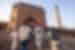 The backs of travellers exploring around New Delhi with Jama Masjid mosque in background
