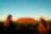 Intrepid travellers laugh together in joy at Uluru at sunset