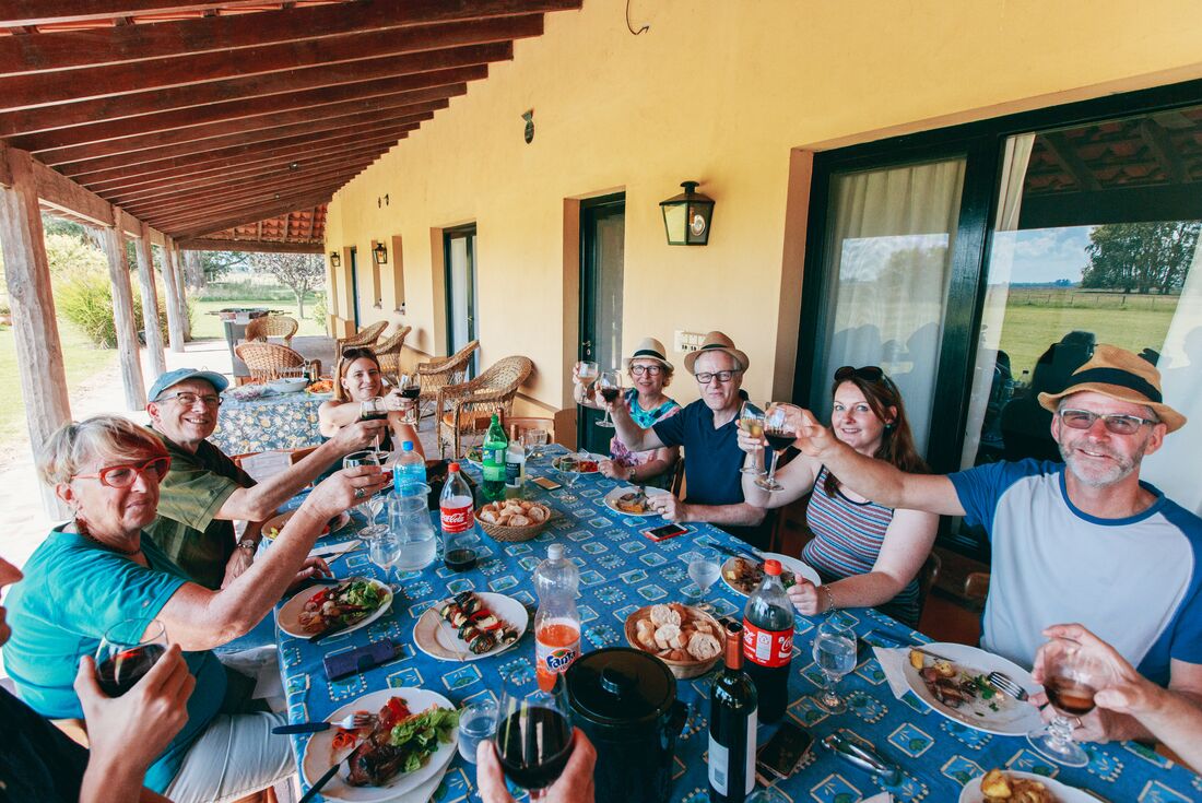 A group of travellers enjoy a meal together at Estancia, Argentina.