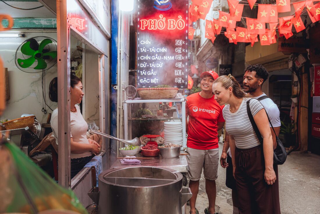 Travellers explore local street food with Intrepid Leader in Hanoi, Vietnam