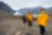 Travellers in yellow Quark coats hiking in the majestic landscape of Blomsterbugten (Flower Bay)