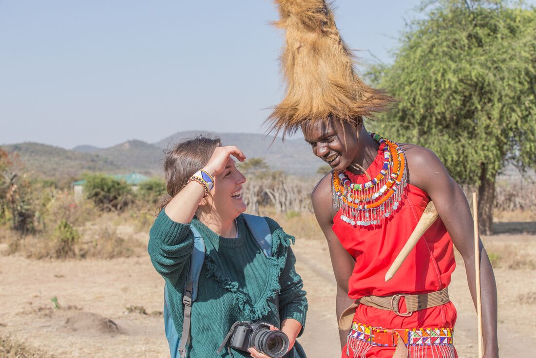 Traveller smiles and laughs with a member of the Maasai people in Loita Hills Kenya