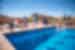 Group of Intrepid traveller children jumping into a pool with the kasbah of Ait Benhaddou in the background