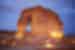 Travellers seated in the sand enjoying twilight at Jabal Alfil, elephant rock, Al Ula, Saudi Arabia