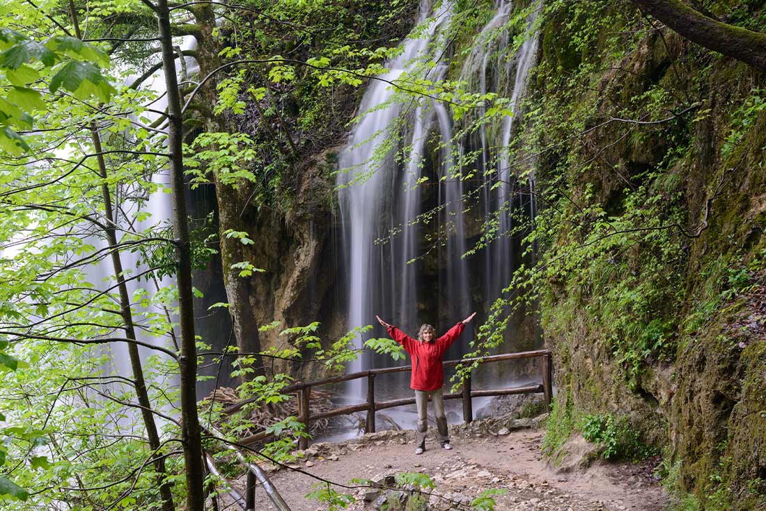 ZMPY - Woman posing in front of waterfall while on hike in Plitvice National Park, Croatia