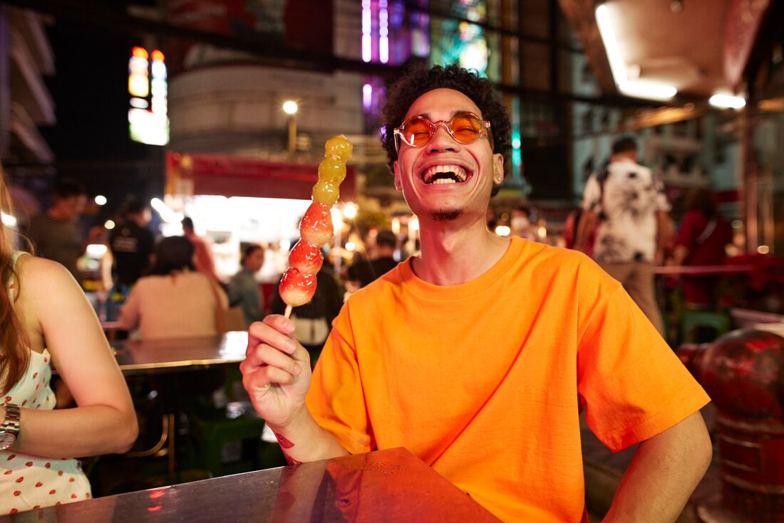 Sharing a sweet strawberry gooseberry treat in Bangkok's street markets
