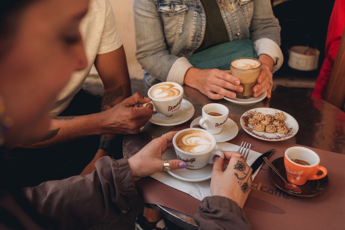 Close-up of three travellers coffees along with small pastries in Rome, Italy
