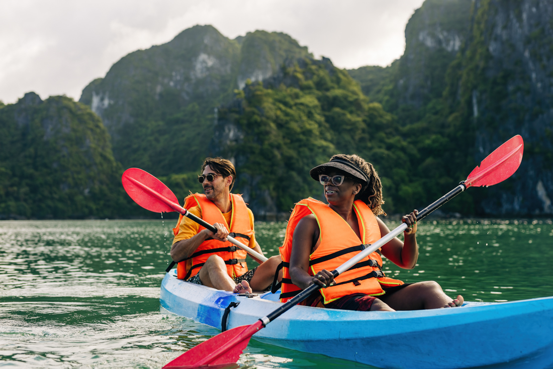 Intrepid travellers kayaking in Ha Long Bay with big smiles