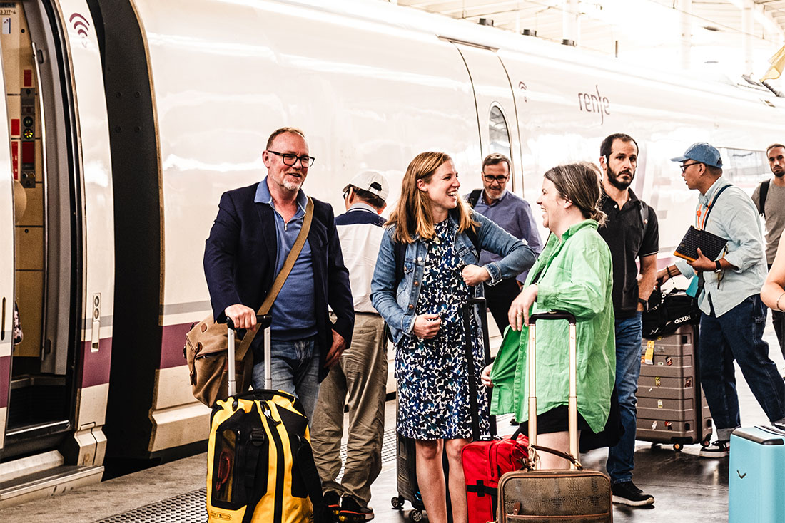 Group of travellers talk and laugh as they board high-speed train in Madrid to Seville, Spain