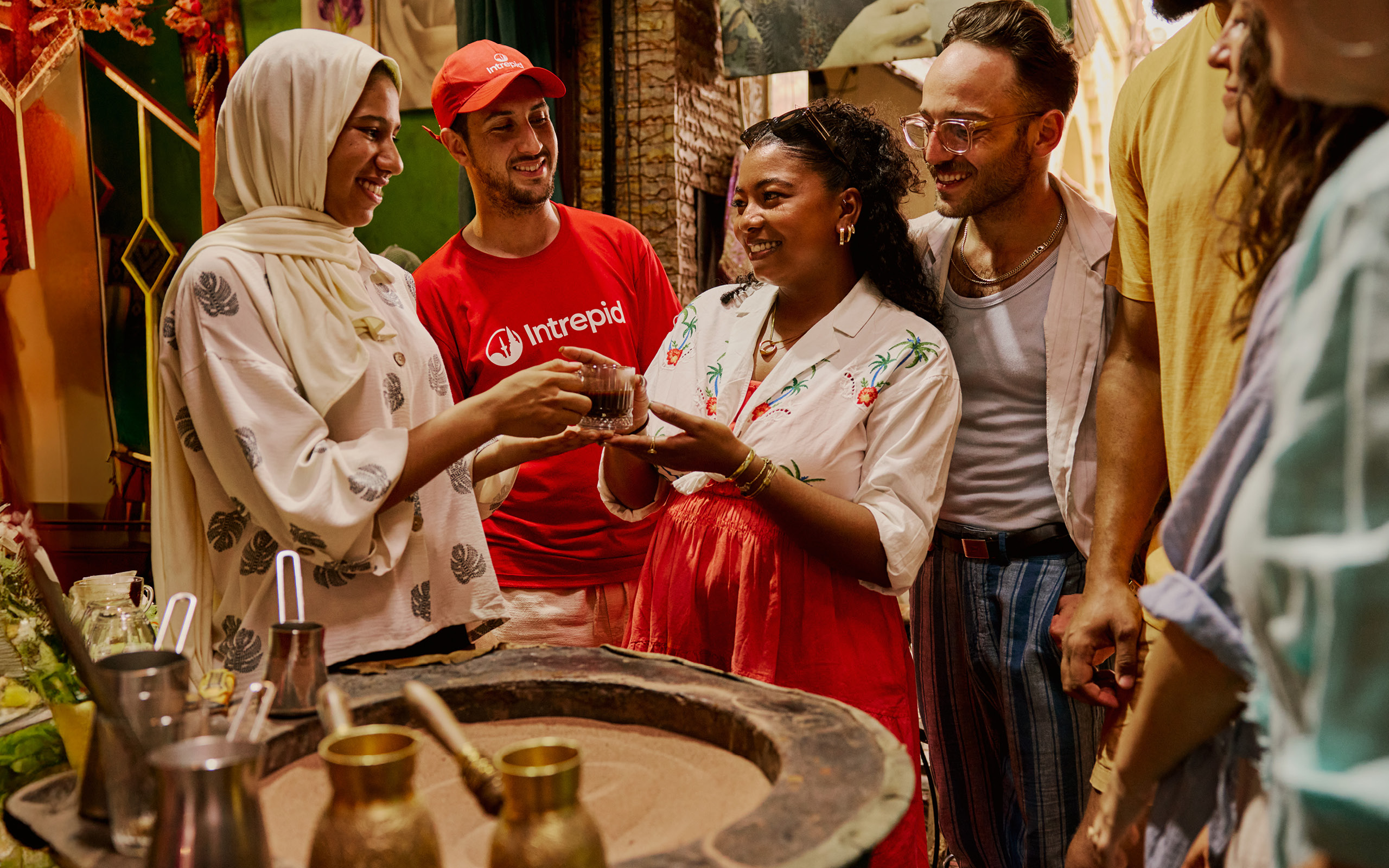 People in a market sipping tea