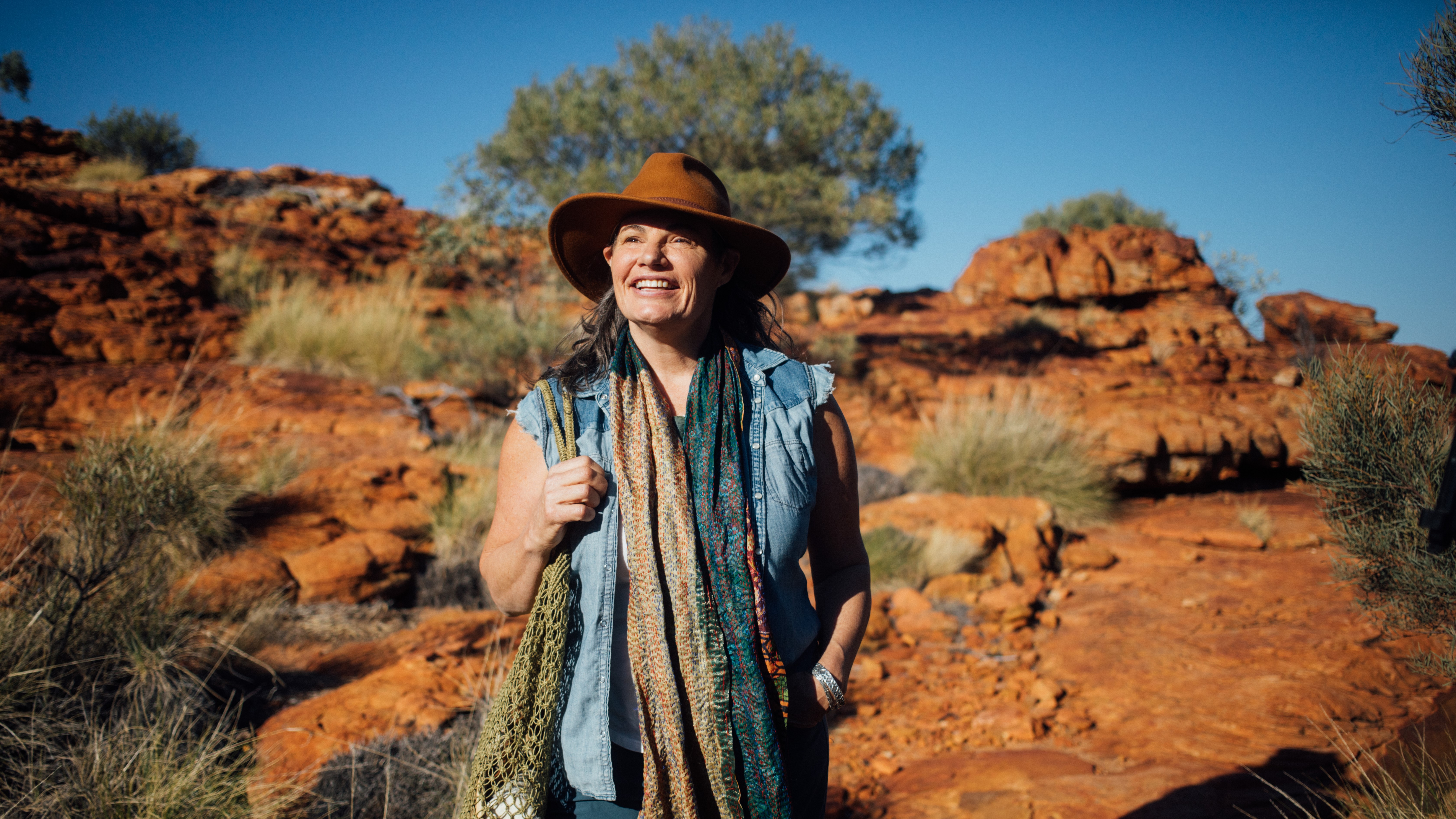 A woman standing in the Australia Outback looks into the distance