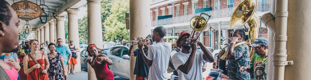 Man playing trombone in the street during and people dance Mardi Gras, New Orleans, Louisiana, USA