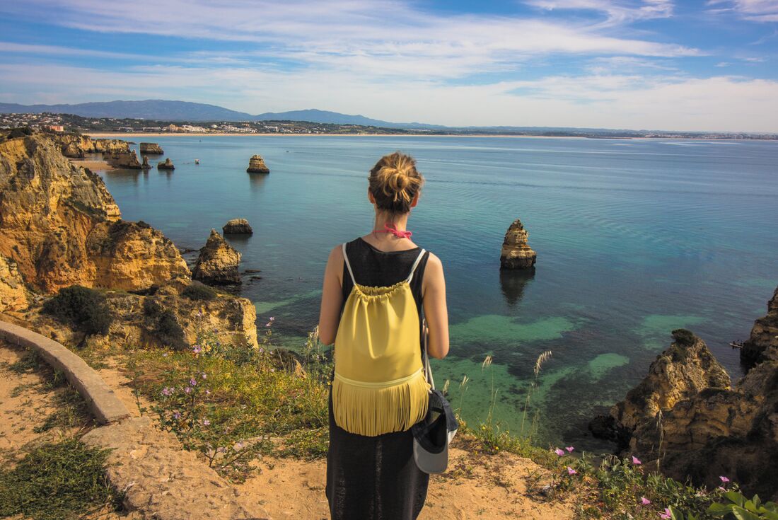 Traveller looking out over the water at Lagos, Portugal