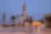 Towering spires of the Great Mosque of Touba at dawn in northern Senegal with locals in foreground