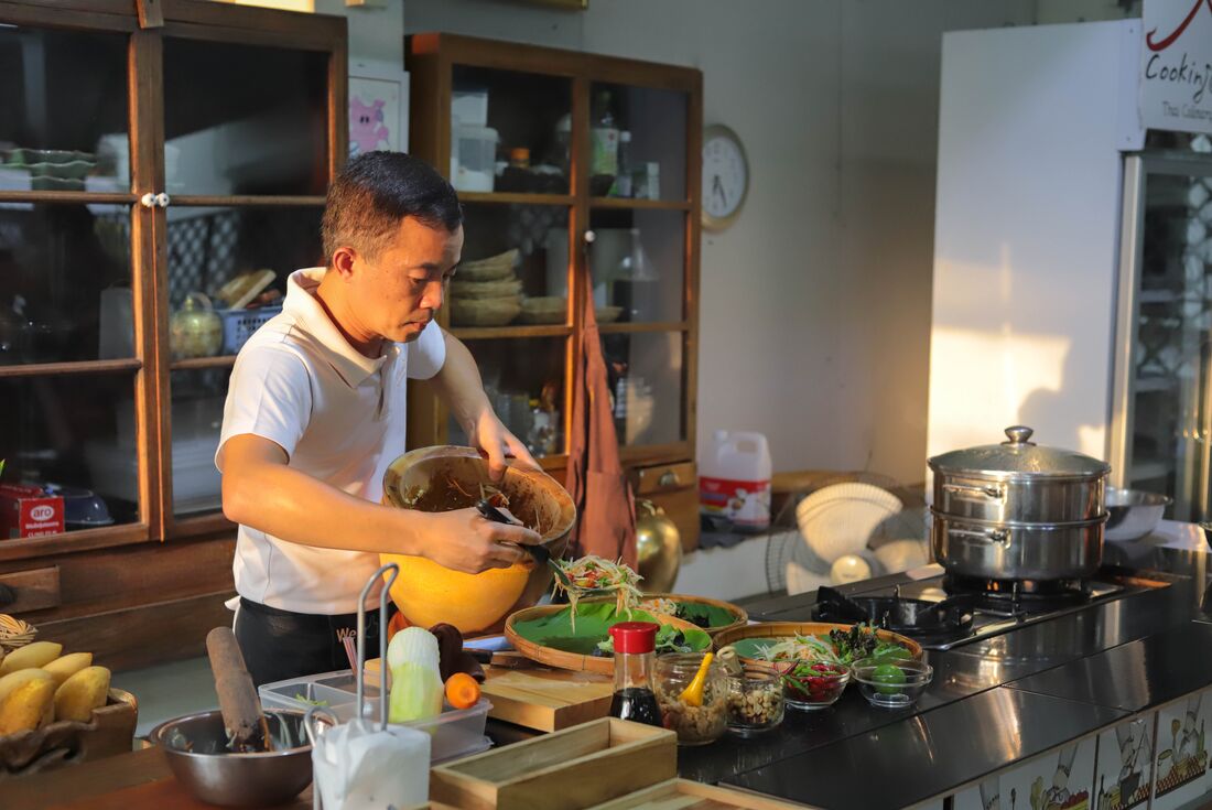 Local guide preparing local cuisine in a cooking class in Thailand
