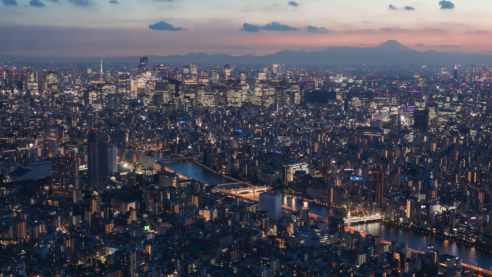 A aerial view of the Tokyo cityscape lit up at night.