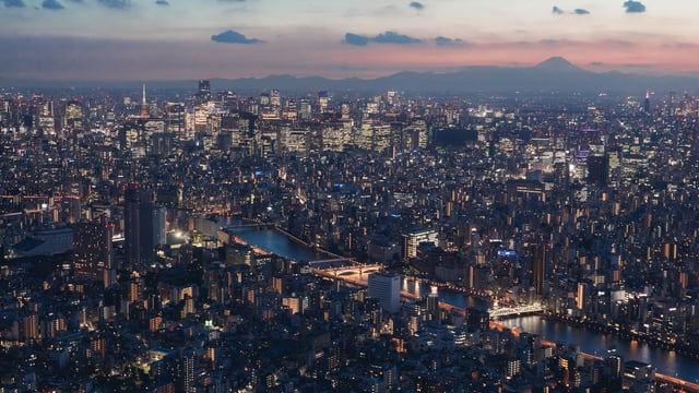 A aerial view of the Tokyo cityscape lit up at night.