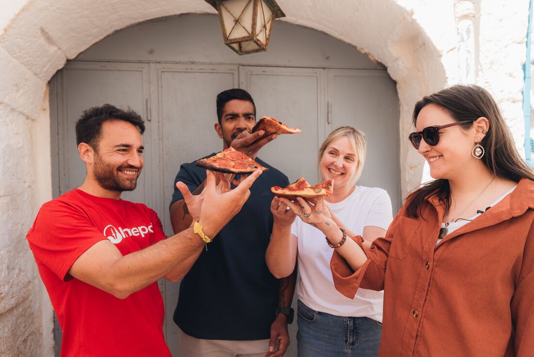 Travellers eating pizza with Leader in Italy