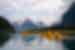 Travellers kayaking across the lake at Milford Sound, New Zealand, with misty mountainscape in the background