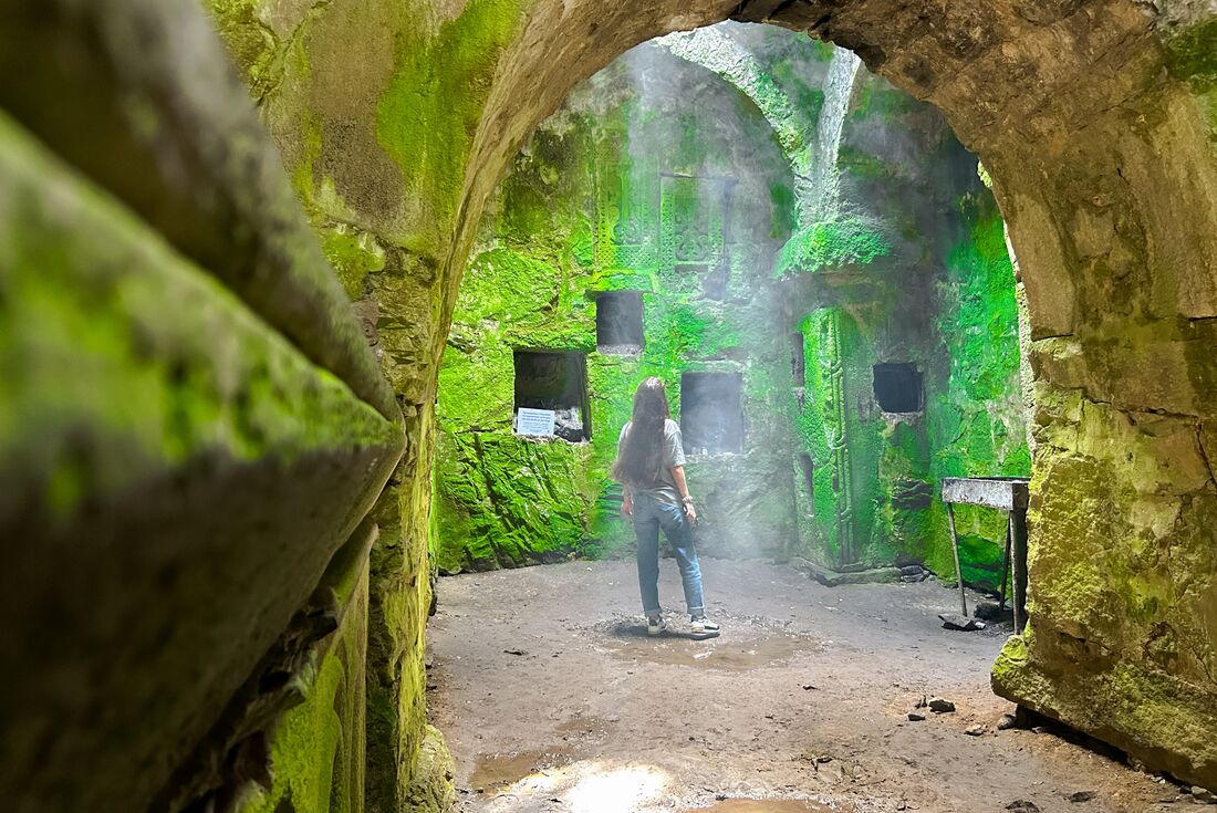 Traveller looks up into an open sky from inside the Matosavank monastery ruins in Dilijan National Park in Armenia