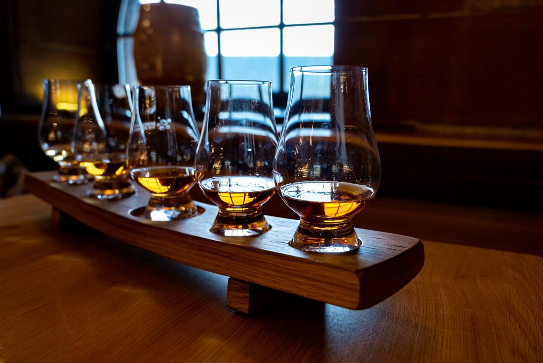 Four whisky tasting glasses lined up in a dimly lit pub in Edinburgh, Scotland 